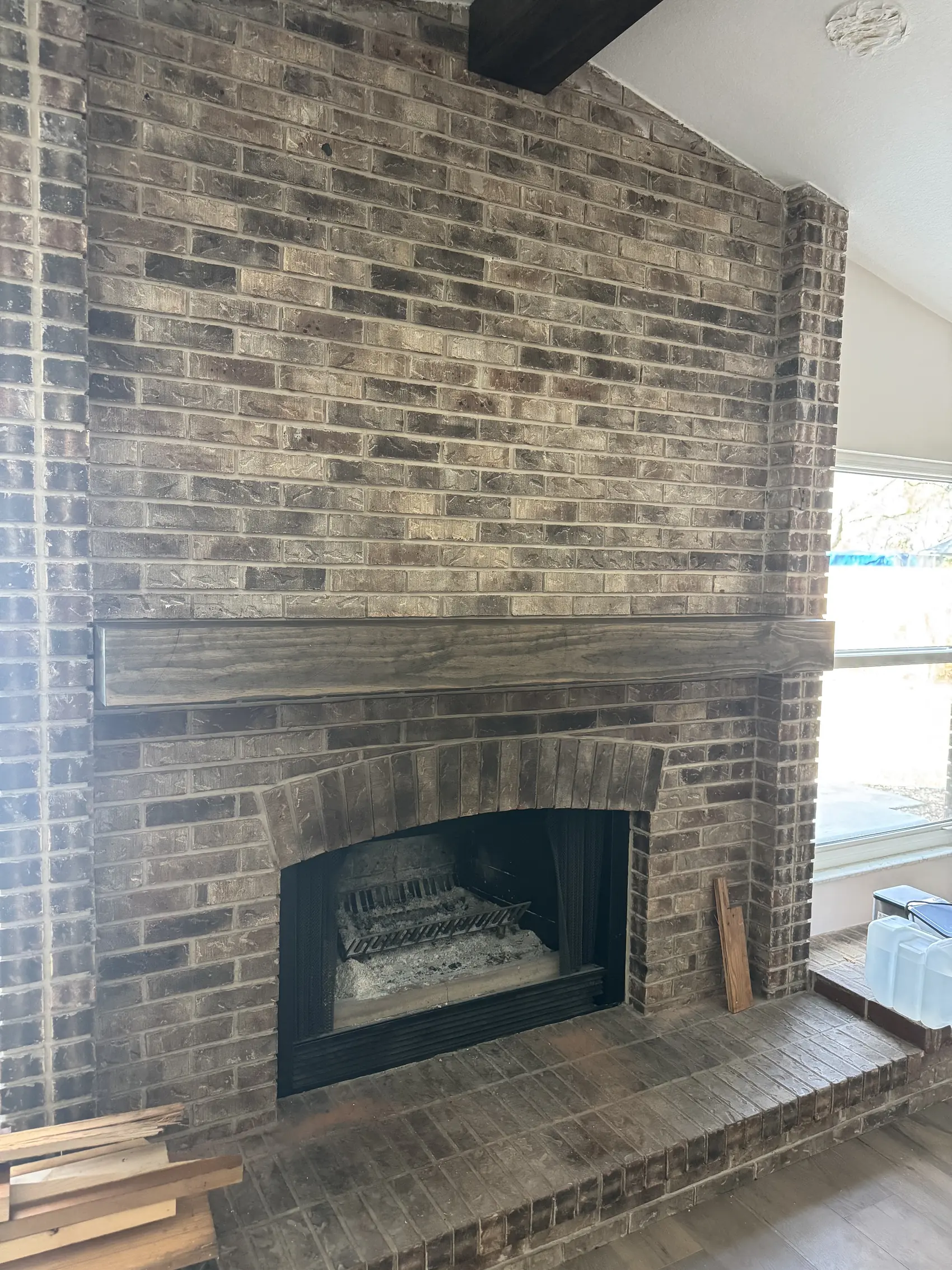 Floor to ceiling brick fireplace with a timber beam set above the opening