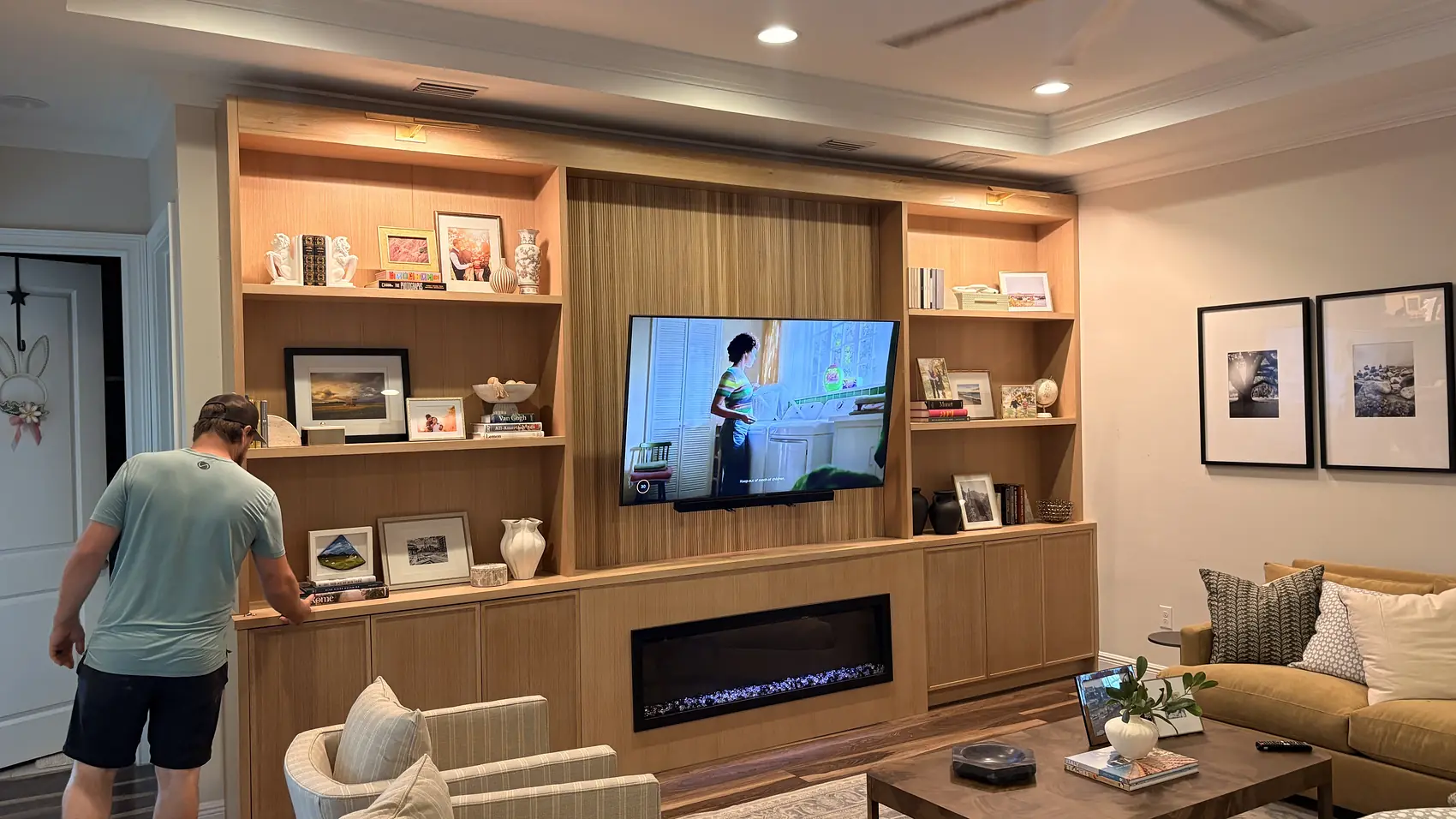 Carpenter setting out the shelves on a finished oak media wall