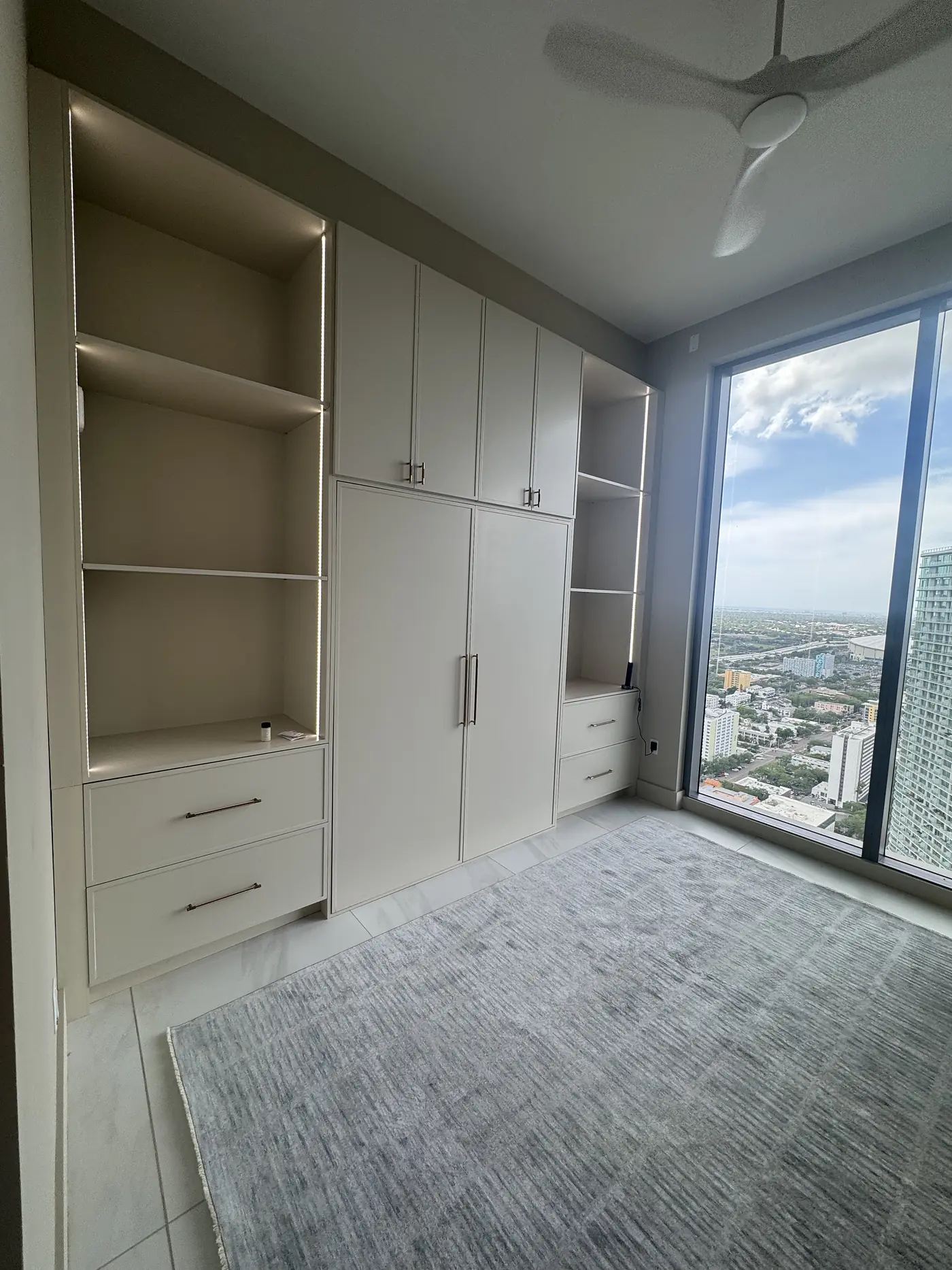 The same wall bed closed flush into a run of built in wardrobes and shelving