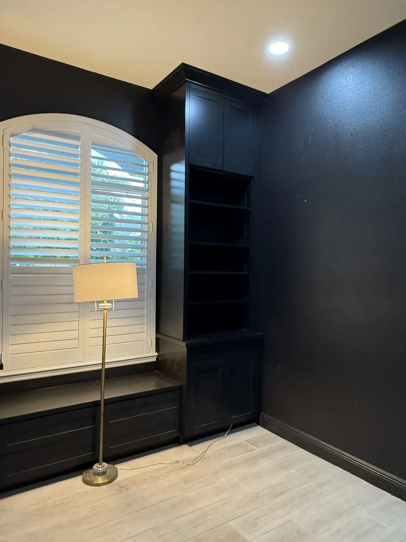 Corner view of dark navy built in shelving and cabinets running up to the ceiling