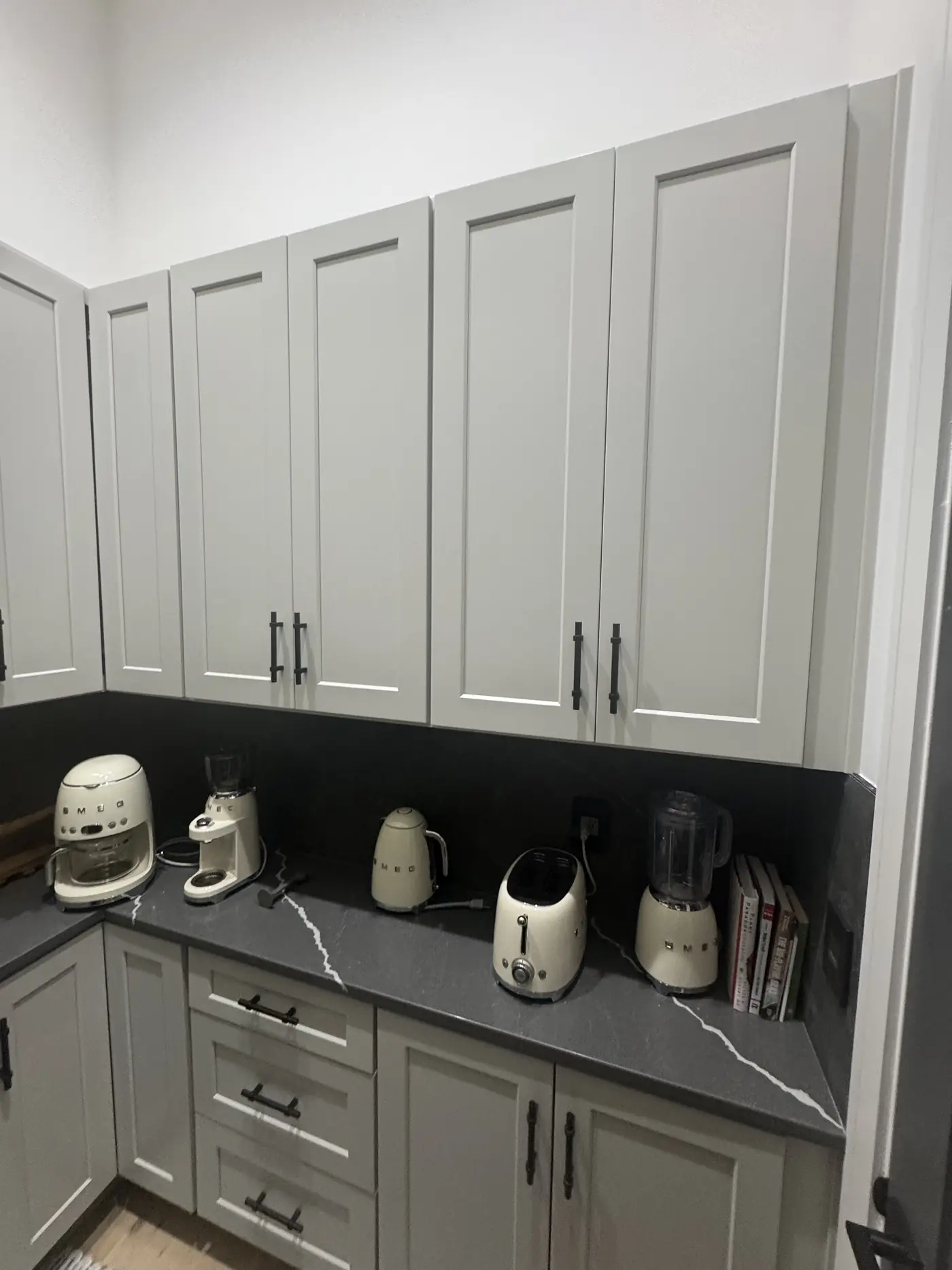 Grey shaker cabinets and a dark stone counter in a butler pantry