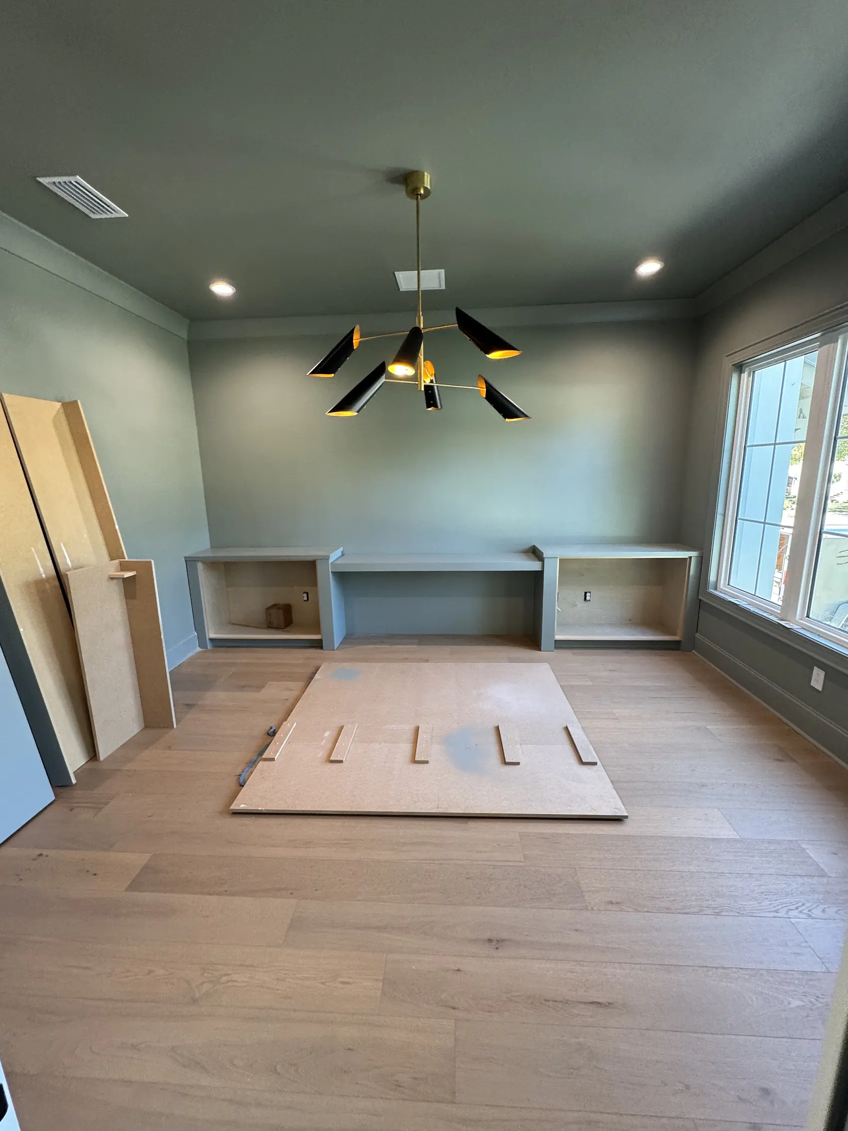 Room with the carcasses of a built in desk and shelving set in place before the doors go on