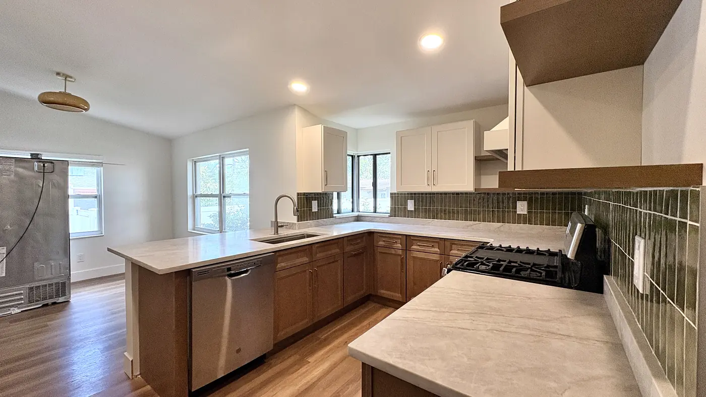 Built up hood over the range in a wood kitchen with green tile behind it