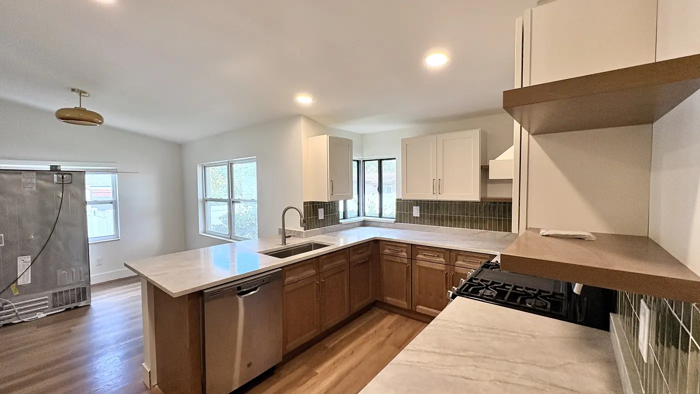 Wood kitchen island and perimeter cabinets with a built up hood over the range