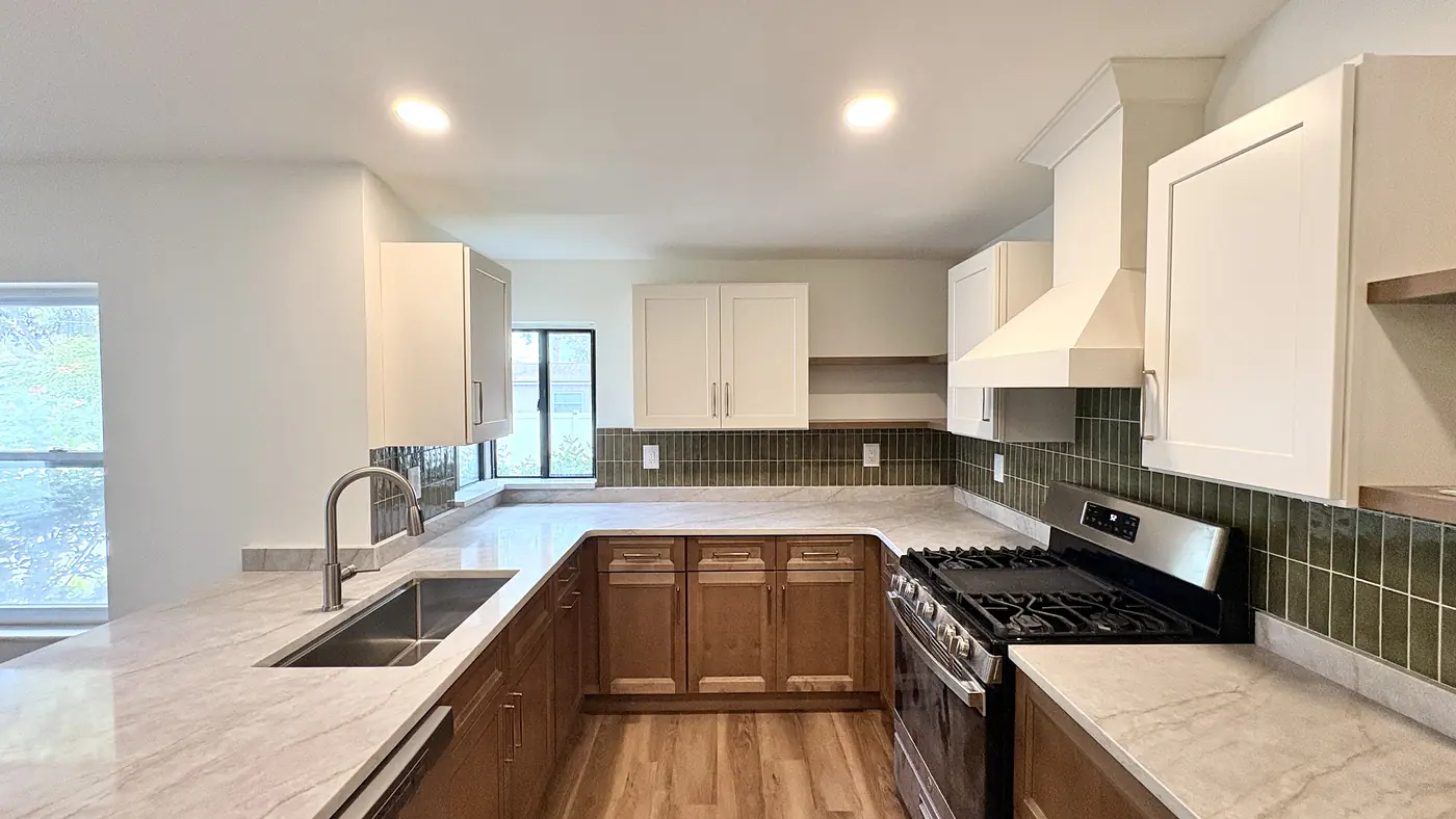 Wood kitchen with the sink under the window and the range set into the run of cabinets